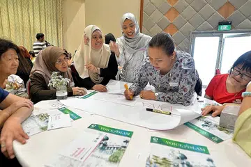 HARAPAN WANITA: Dr Elly (empat dari kanan) mengajak sekumpulan wanita, termasuk Cik Sa'adiah (sedang menulis) dan Cik Jamaliah (tiga dari kiri), yang menghadiri acara sarapan lewat pagi anjuran Jamiyah berbincang tentang aspirasi mereka dan isu yang mereka hadapi dalam dunia yang berubah-ubah sekarang. - Foto ZAINAL YAHYA