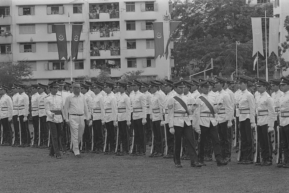 Menteri Pembangunan dan Komunikasi, Encik Lim Kim San, memeriksa Kawalan Kehormatan semasa Perbarisan Hari Kebangsaan (NDP) di padang Sekolah Redhill pada 9 Ogos 1975.