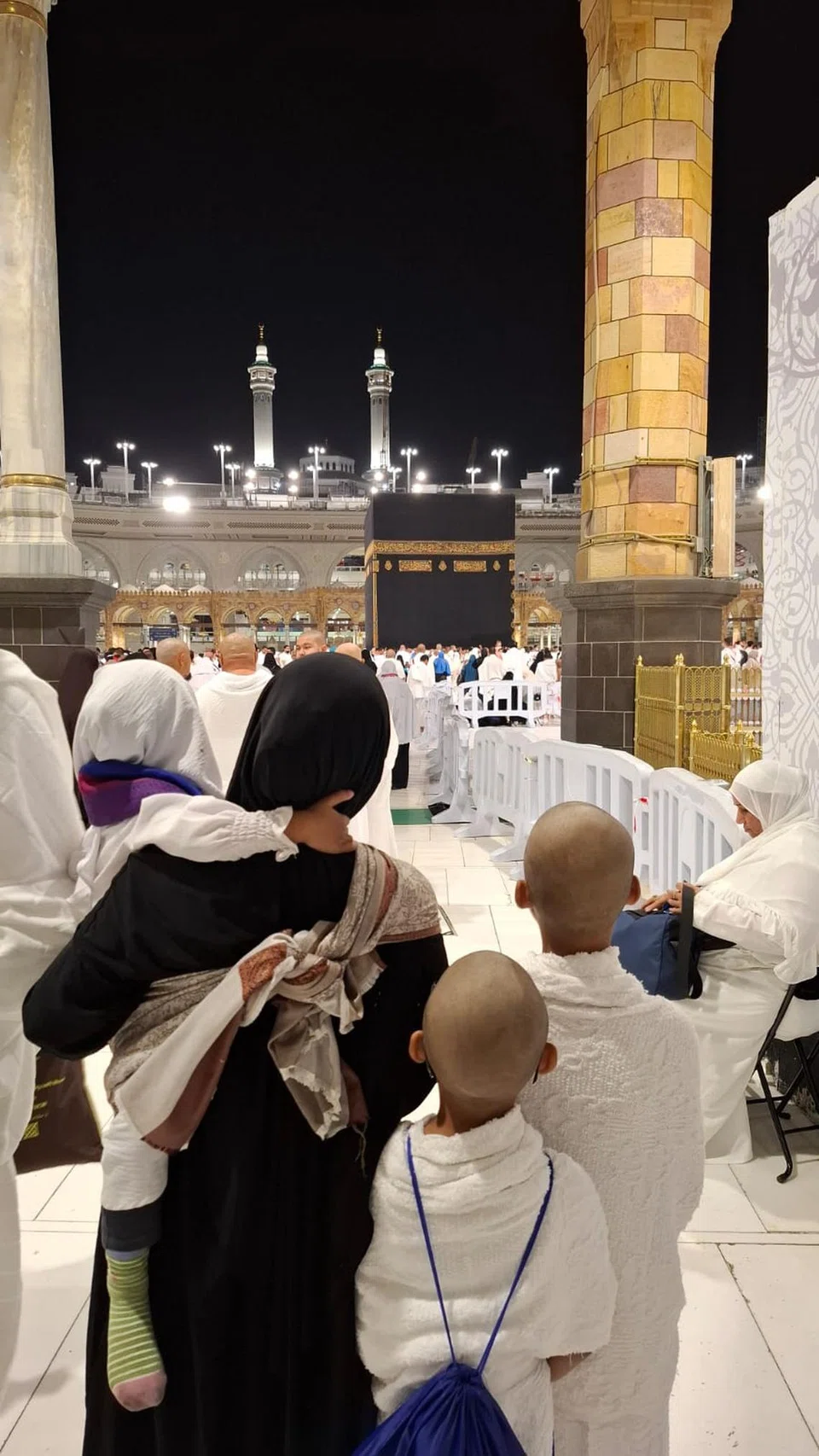 Cik Nur Syahidah mendukung anaknya sambil menuju ke Kaabah di Makkah.
