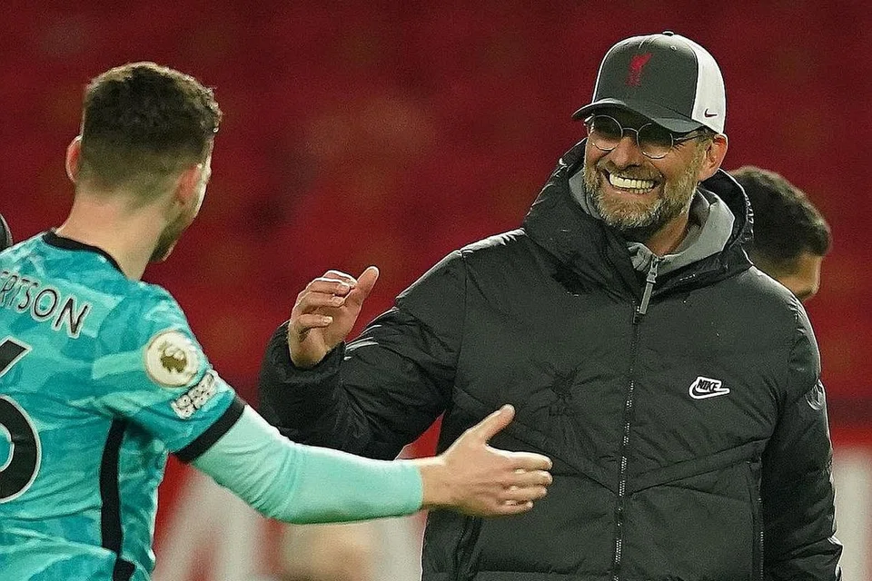 KEMENANGAN PENTING: Klopp (kanan) meraikan kemenangan Liverpool 4-2 ke atas Manchester United bersama Robertson (kiri). - Foto EPA-EFE