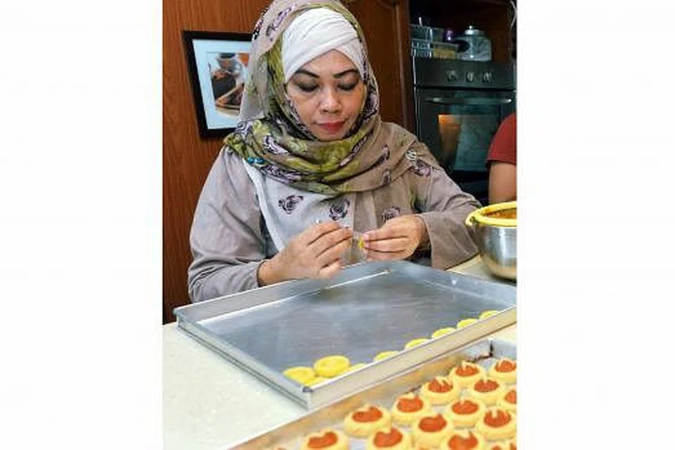 SEPIT SENDIRI: Meskipun jumlah tempahan daripada pelanggan tetapnya boleh mencecah sehingga 10,000 tart setiap musim Hari Raya, Cef Tania masih tetap menyepit doh tart yang ditempah itu secara manual. - Foto-foto KHALID BABA HASIL 