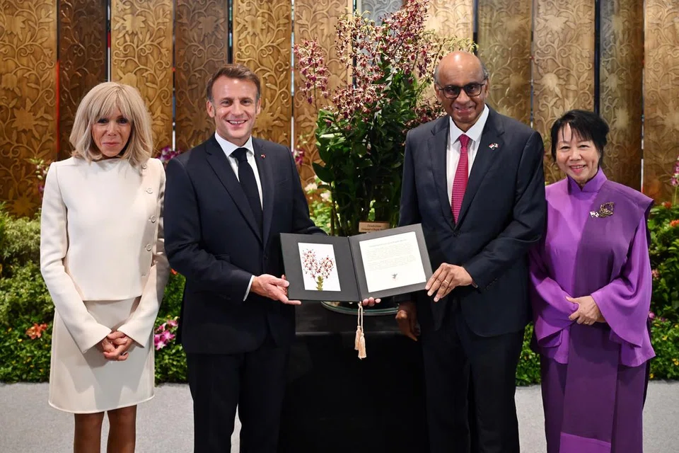Presiden Perancis, Encik Emmanuel Macron (dua dari kiri) dan isterinya Cik Brigitte Macron (kiri) bersama Presiden Tharman Shanmugaratnam (dua dari kanan) dan isterinya, Puan Jane Ittogi (kanan), di Upacara penamaan Orkid yang diadakan di Bangunan Parlimen pada 30 Mei.