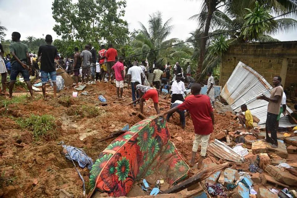 Orang ramai mencari mangsa dan mayat di tempat kejadian tanah runtuh di Anyama, dekat Abidjan.