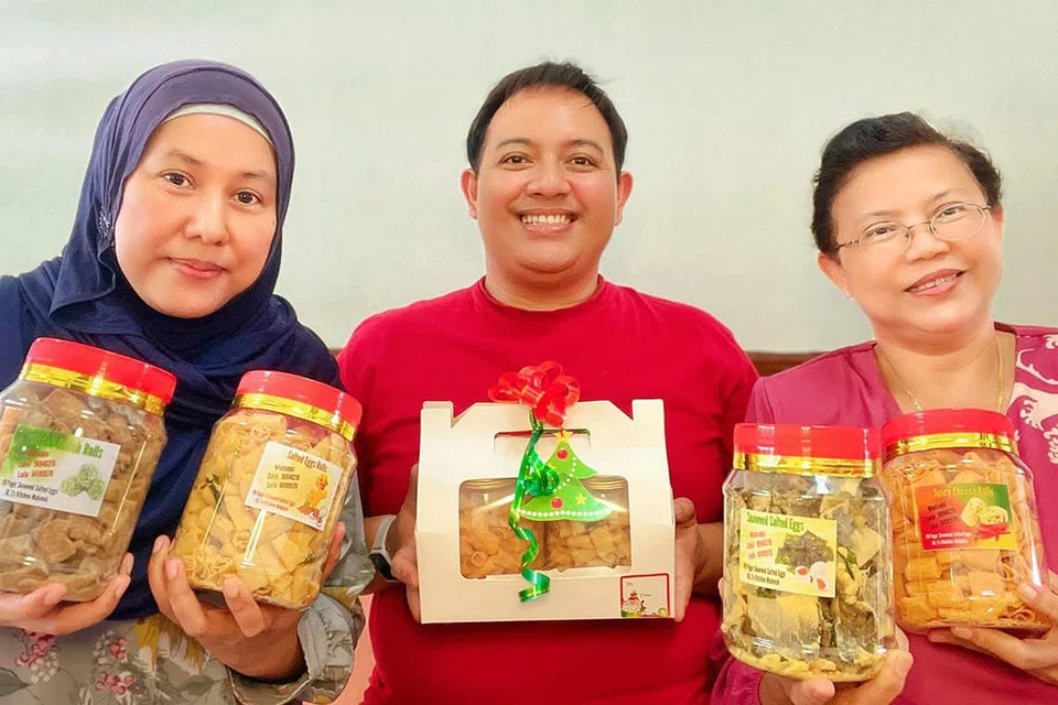 TETAP LARIS MESKI COVID-19: Encik Mohammad Zahid Mohd Ali (tengah) bersama rakan niaganya Cik Hazilah Mohd Ali (kiri) dan Cik Zainab Idris. Perniagaan makanan dalam talian mereka, J's Kitchen MakMok tetap mendapat sambutan hangat daripada pelanggan mereka, khususnya di musim perayaan. - Foto ihsan MOHAMMAD ZAHID MOHD ALI
