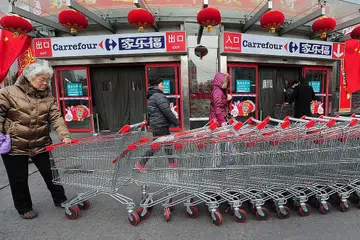 PERTUMBUHAN PENTING EKONOMI DI ASIA: Seorang wanita menolak troli di luar pusat beli-belah Carrefour di Beijing. Kadar pertumbuhan Asia lebih tinggi berbanding dengan rantau lain. Ia menyumbang kepada kira-kira separuh daripada pertumbuhan global pada tahun lepas. - Foto AFP