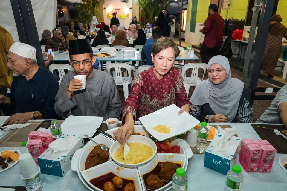 Menteri Penerangan dan Pembangunan Digital, Cik Josephine Teo (dua dari kanan), menjamu sajian dalam acara iftar di Masjid Omar Kampong Melaka (MOKM) pada 12 Mac sambil ditemani (dua dari kiri) Pengerusi Kehormat MOKM, Ustaz Dr Mohammad Yusri Yubhi Md Yusoff dan Sharifah Zahra Syed Junied Aljunied, generasi kelima saudagar dermawan Syed Omar Ali Aljunied.