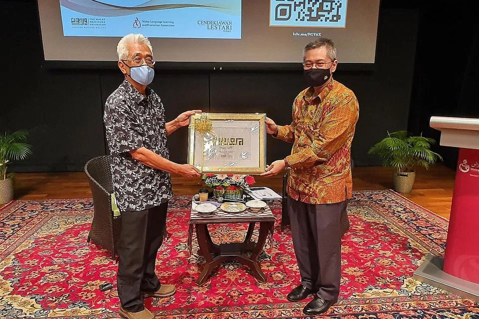 SESI PERBINCANGAN: Moderator sesi CLS semalam, Dr Norshahril (kanan) menyampaikan cenderhati sebagai penghargaan kepada Cikgu Maarof yang telah menyampaikan ceramahnya berkaitan identiti Melayu Singapura. - Foto MHF