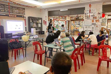 KENALI ALAT BIJAK: Cik Febby Lee, siswi NTU dan pengasas bersama kempen '#CanOneLah!', buat penyampaian ringkas tentang telefon bijak kepada warga emas di bawah pusat kegiatan warga emas Pusat Penjagaan Masyarakat Xin Yuan. - Foto #CANONELAH!