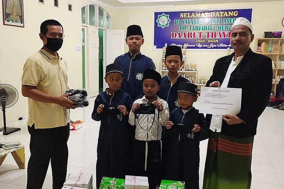 BANTU GOLONGAN SUSAH: Habuan nasi kotak serta barang asas lain yang disumbang oleh pelanggan dan kenalan Encik Abdul Rahman Ibrahim daripada Urutan Therapy Singapura disampaikan kepada kanak-kanak di pesantren di Batam. Selain itu, syarikat beliau bergabung tenaga dengan Pengurusan Jenazah Sinaran Baharu (PJSB) untuk mengagihkan habuan seperti beras, minyak dan gula kepada golongan memerlukan di Singapura. - Foto ihsan ABDUL RAHMAN IBRAHIM