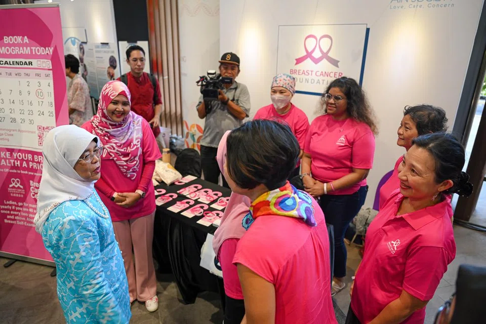 USAHA TINGKAT KESEDARAN: Presiden Halimah Yacob (baju biru) mengunjungi sebuah  reruai yang berkongsi maklumat tentang saringan barah semasa pelancaran kempen Kesan Awal Barah Terkawal: Yok Screening! anjuran Persatuan Ain di Wisma Geylang Serai pada Ahad.