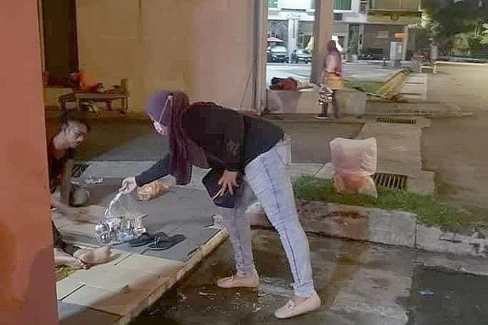 DIBANTU: Seorang relawan Persatuan Belia Bintang Selatan JB menghulurkan bantuan makanan kepada gelandangan di Johor Bahru. - Foto NOR AKMAL MUHAMMAD