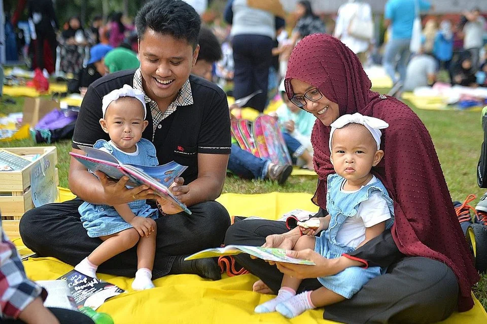 PERTINGKAT MASYARAKAT: Pasangan ini serta anak-anak kecil mereka antara peserta di acara Membaca @ Taman di Persisiran anjuran Mendaki tahun lalu. - Foto fail