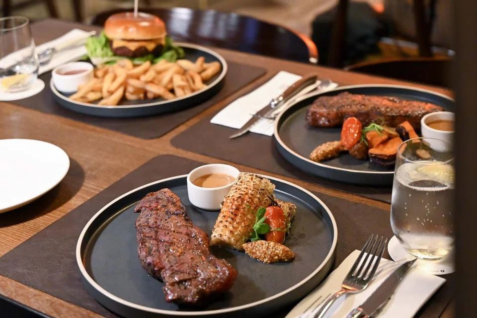 Hidangan ‘Southern Range Striploin’ (depan) dan ‘Wagyu Burger’ (belakang, kiri). 