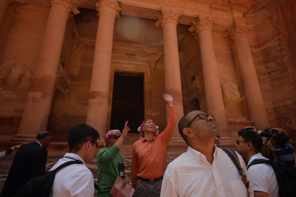 PENINGGALAN SEJARAH: Encik Lee (berbaju oren) melihat keindahan seni bina Petra, di selatan Jordan. Ia dipercayai dibangunkan seawal 312 Sebelum Masehi. - Foto THE STRAITS TIMES