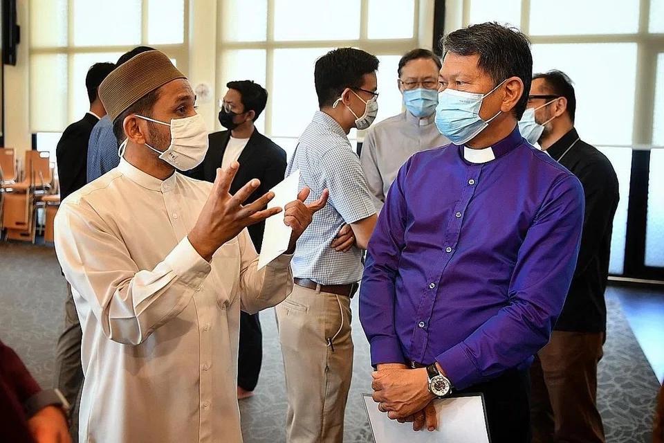 KUNJUNGAN: Presiden Majlis Gereja Kebangsaan Singapura (NCCS), Reverend Keith Lai (kanan) berbual dengan Mufti Dr Nazirudin Nasir (kiri) di Masjid Yusof Ishak . Di belakang turut kelihatan beberapa pemimpin Kristian dan Islam sedang berinteraksi. - Foto BH oleh CHONG JUN LIANG
