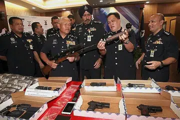 DIRAMPAS: Pengarah Jabatan Siasatan Jenayah Bukit Aman Datuk Seri Mohmad Salleh (dua dari kiri) menunjukkan raifal yang dirampas dalam Ops Cantas Khas Jenayah Terancang pada sidang akhbar di Ibu Pejabat Polis Kontinjen Kuala Lumpur. - Foto THE STAR