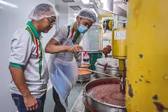 BERSEDIA UNTUK PASARAN EKSPORT: Encik Norhashim (kiri) melihat pekerjanya membuat pes di kilang mereka yang terletak di Admiralty Food Exchange. - Foto BH oleh NUR DIYANA TAHA
