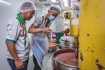 BERSEDIA UNTUK PASARAN EKSPORT: Encik Norhashim (kiri) melihat pekerjanya membuat pes di kilang mereka yang terletak di Admiralty Food Exchange. - Foto BH oleh NUR DIYANA TAHA