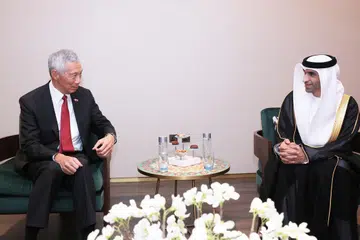 DISAMBUT MESRA: Ketibaan Encik Lee (kiri) di Lapangan Terbang Antarabangsa Dubai pada Jumaat disambut Menteri Negara Perdagangan Ehwal Luar UAE, Dr Thani Ahmed Al Zeyoudi (kanan).