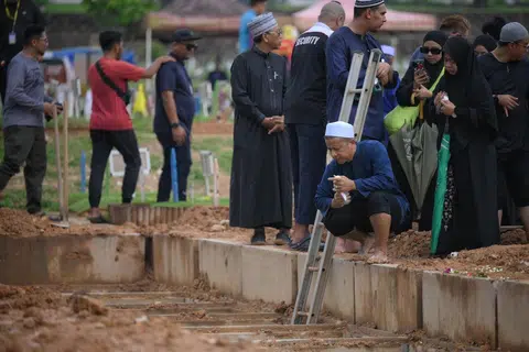 Abang kepada Allahyarhamha Norzihan Juwahib, Encik Salimi Juwahib (berjubah), dan adiknya, Encik Sani Juwahib, setelah pengebumian arwah  disempurnakan di Pusara Aman pada 23 April.