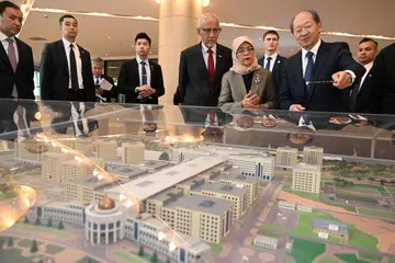KUNJUNGAN UNIVERSITI: Encik Shigeo Katsu, Presiden Universiti Nazarbayev (dua dari kanan) menunjukkan model kampus kepada Presiden Halimah Yacob (empat dari kanan) dan suaminya, Encik Mohammed Abdullah Alhabshee (lima dari kanan) pada Selasa.
