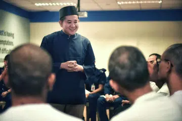KONGSI PANDANGAN: Encik Amrin bercakap dengan pesalah dadah dalam sesi dialog di DRC sebelum beliau berbuka puasa bersama mereka pada Selasa (14 Mei).