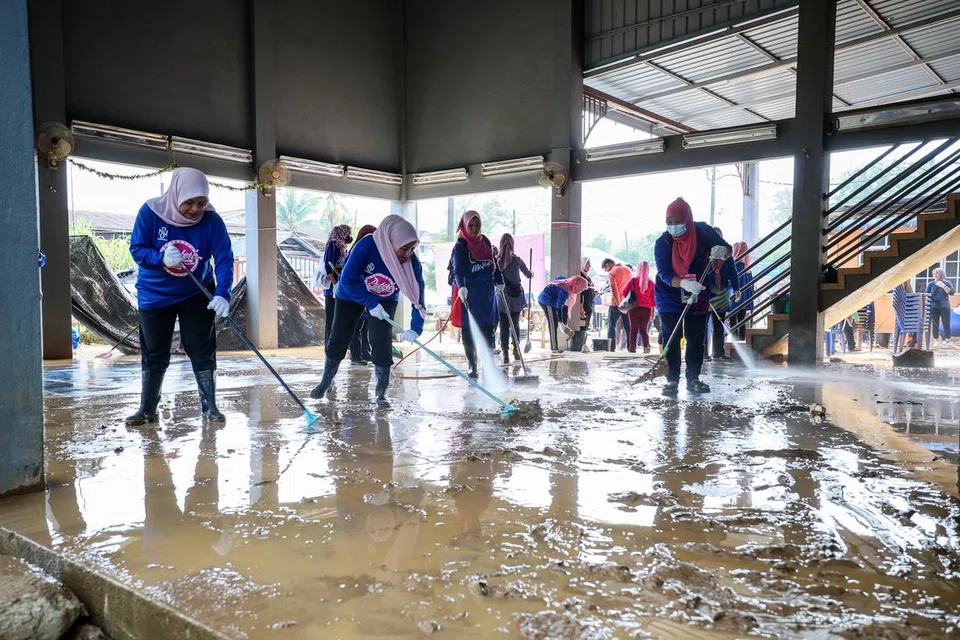 BERSIHKAN KAWASAN BANJIR: Sukarelawan Puteri Umno bertungkus lumus membersihkan dewan masyarakat yang terkesan akibat banjir baru-baru ini di Kampung Pengkalan Ajal, Terengganu.