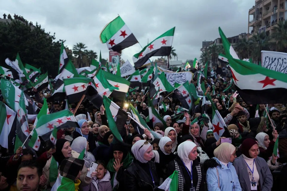 Orang ramai di Syria mengibarkan bendera ketika berhimpun bagi memperingati ulang tahun pertama kejatuhan mantan Presiden Bashar al-Assad, di Latakia, Syria, pada 8 Disember 2025. 