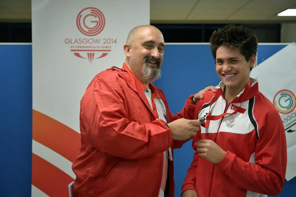 Joseph Schooling (kanan) meraikan kejayaan memenangi pingat perak dalam acara 100m kupu-kupu bersama jurulatihnya pada masa itu, Sergio Lopez, di Pusat Renang Antarabangsa Tollcross pada 28 Julai 2014. Kemenangan pingat perak ini merupakan pencapaian pertama dalam sukan renang untuk Singapura. 
