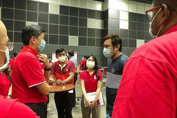 BANTUAN DISEDIAKAN: Setiausaha Agung NTUC Encik Ng Chee Meng (kiri) bercakap dengan Encik Suhairi (kanan) yang kini menumpukan usahanya meraih kemahiran baru dan mendapatkan pekerjaan alternatif. - Foto NG CHEE MENG / FACEBOOK