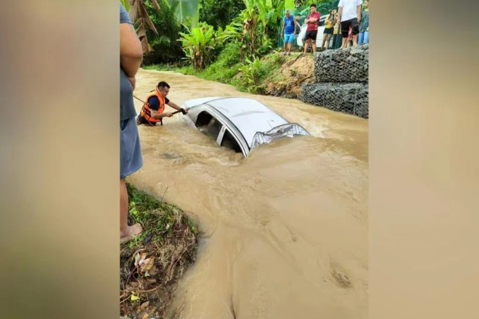 Anggota Jabatan Bomba dan Penyelamat Malaysia berusaha mengeluarkan mayat seorang lelaki yang terperangkap dalam kereta yang terbabas ke dalam parit ketika banjir kilat melanda Kapit, Sarawak, pada pagi 27 November.