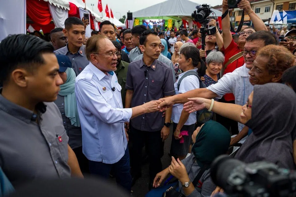Perdana Menteri Malaysia, Datuk Seri Anwar Ibrahim (dua dari kiri) dikenali dengan sikap ramah dalam menyantuni rakyat.