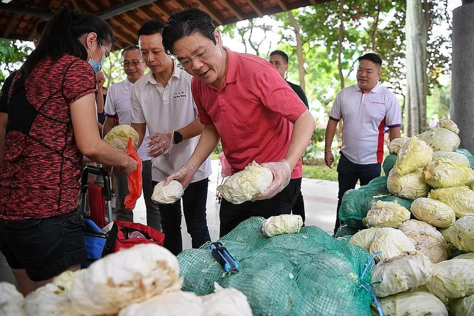 PROJEK 'SELAMATKAN' MAKANAN: DPM Lawrence Wong (dua dari kanan) dan Encik Yip Hon Weng (sebelah kanan DPM) menyertai pemberian makanan yang telah 'diselamatkan' kepada mereka yang memerlukannya. - Foto BH oleh CHONG JUN LIANG