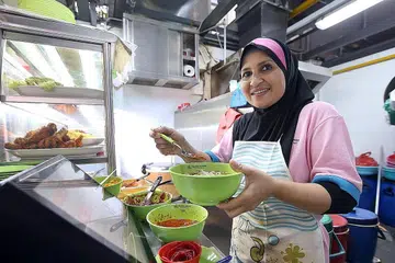 SEDIAKAN PILIHAN LEBIH SIHAT UNTUK PELANGGAN: Cik Salma Salim menyediakan mi soto lebih sihat dengan, antara lain, membuang lemak ayam dan tidak menggunakan minyak bagi menghasilkan kuahnya. - Foto MCI