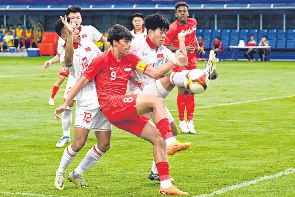 REBUT BOLA: Kapten Singapura, Haryhs Stewart (jersi merah), mengawal bola daripada pemain Vietnam. Skuad bola sepak kebangsaan lelaki bawah 22 tahun sekali lagi menemui jalan buntu dalam perjalanan Sukan SEA mereka selepas tewas 1-3 dengan Vietnam. Skuad Singa sebelum ini juga tewas 1-3 di tangan Thailand dalam perlawanan pembukaan kumpulan B. Dengan keputusan ini, peluang Singapura untuk mara ke peringkat seterusnya semakin tipis. Skuad kendalian Philippe Aw itu memerlukan keajaiban dan perlu memenangi semua baki perlawanan untuk mara. Mereka bakal berdepan dengan Laos pada Sabtu. - Foto ST
