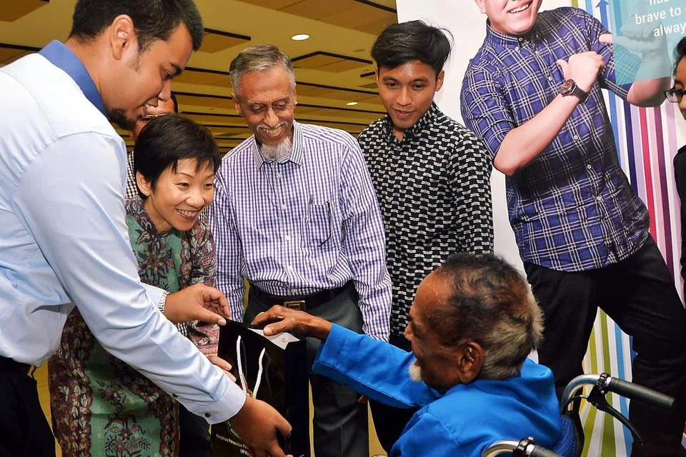 PERKASA GOLONGAN SUSAH: Cik Grace Fu memberikan habuan kepada Encik Hashim Mohd (duduk di kerusi roda) semasa pelancaran ROW semalam. - Foto KHALID BABA