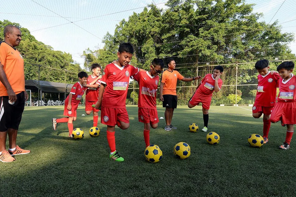 BIMBING LATIHAN: Ismail (kiri) dengan dibantu seorang lagi jurulatih, Muhd Firdaus Khalif (tengah), membimbing pemain mudanya sebagai persiapan menghadapi cabaran Piala Gothia di Sweden yang berlangsung pada 16-23 Julai ini. - Foto ZAINAL YAHYA