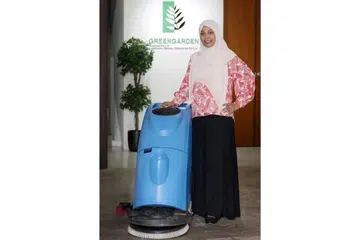 TERUS DIBANTU: Perusahaan akan terus dibantu dan digalak pemerintah untuk berinovasi. Cik Abedah A. Nasir, pengarah pembangunan syarikat Green Garden Cleaning bersama alat pembersihan baru yang dibeli melalui geran pemerintah. - Foto BH oleh JOEL CHAN
