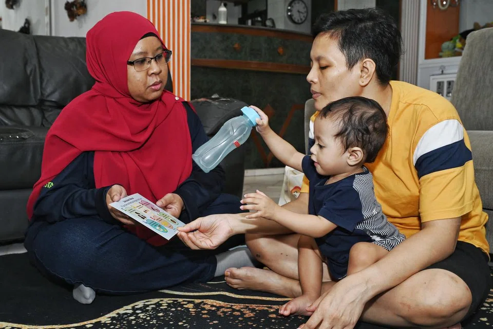 Pengamal program KidSTART, Cik Nur Hidayah Hashim (kiri), berinteraksi dengan peserta program, Cik Wahidah Ahmad, dan anaknya yang masih kecil. 