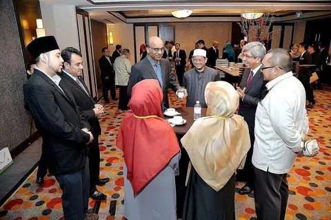 MENGIKTIRAF PERANAN FATWA: Timbalan Perdana Menteri, Encik Tharman Shanmugaratnam (berdiri di tengah menghadap kamera), Mufti Dr Mohamed Fatris Bakaram dan Dr Yaacob Ibrahim bersama beberapa hadirin di Persidangan Fatwa Dalam Masyarakat Kontemporari anjuran Majlis Ugama Islam Singapura (Muis). - Foto M.O. SALLEH