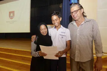 TERSENYUM LEBAR: Iraj (tengah), yang menerima keputusan GCE peringkat 'O' di Sekolah Menengah Serangoon Garden, berjaya meraih keputusan memuaskan membanggakan ibunya, Cik Maskana Jaffar, 55 tahun, serta bapanya, Encik Mohammed Ashfaq Khan, 59 tahun. - Foto BH oleh IQBAL FAIZAL