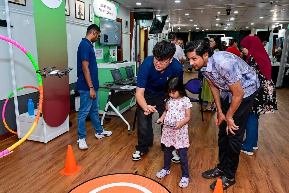 Seorang kanak-kanak mencuba kegiatan menerbang dron yang dikendalikan oleh Politeknik Ngee Ann, salah satu rakan kongsi Raikan Ilmu 2026.