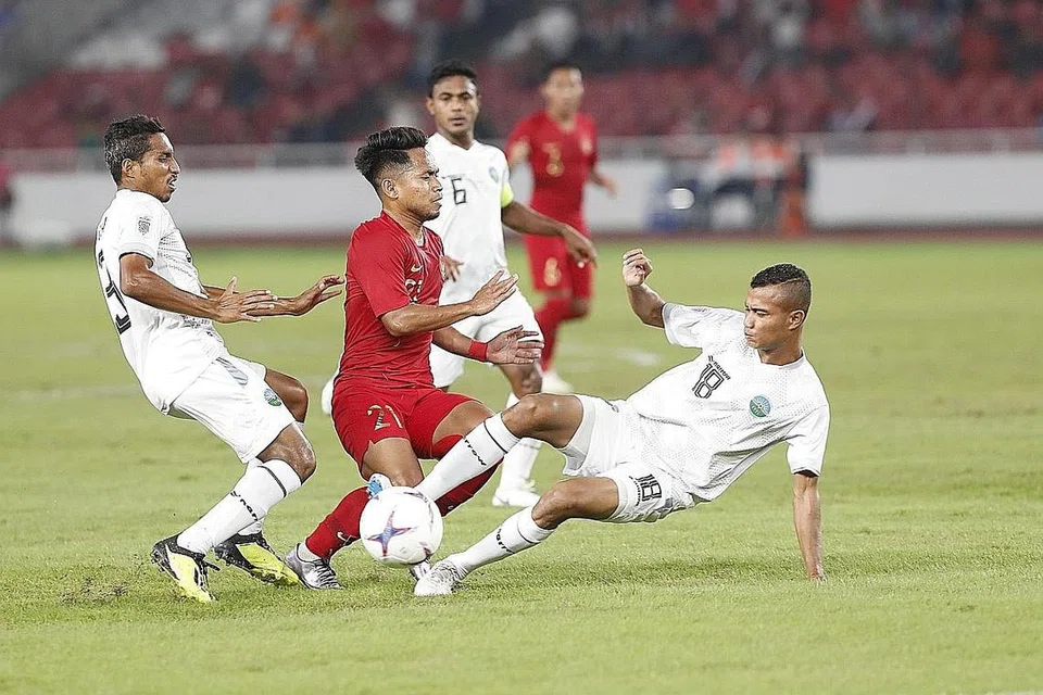 LEBIH HEBAT: Pemain Indonesia Andik Vermansah (tengah, jersi merah) menunjukkan ketangkasannya semasa pasukannya menewaskan Timor-Leste 3-1 kelmarin. - Foto EPA-EFE