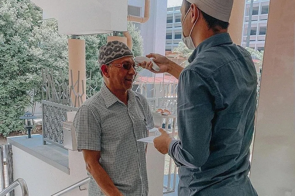 PERIKSA SUHU BADAN: Pemeriksaan suhu badan dijalankan di Masjid Al-Muttaqin. Gambar ini diterbitkan di laman Instagram masjid itu pada 10 Mac lalu. - Foto INSTAGRAM ALMUTTAQINSG