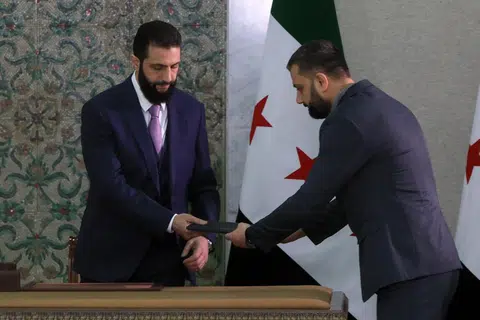Presiden sementara Syria, Encik Ahmad al-Sharaa (kiri), menerima deklarasi perlembagaan negara yang akan dikuatkuasakan sepanjang tempoh peralihan selama lima tahun, sebelum menandatanganinya di Istana Presiden di Damsyik pada 13 Mac. 