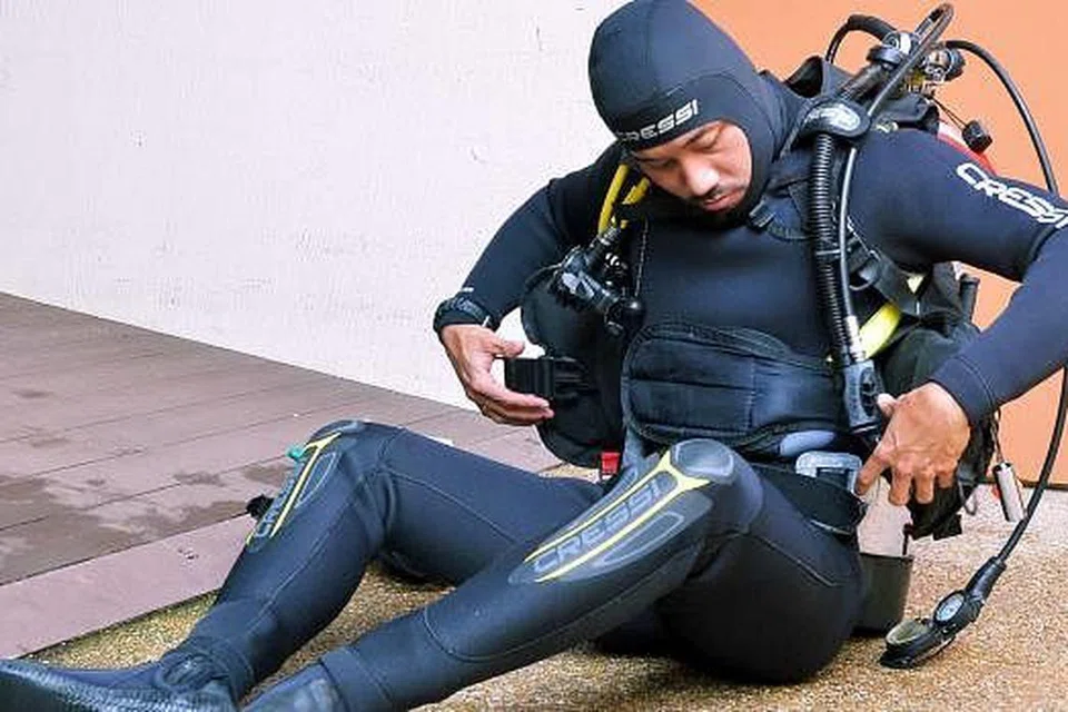 ANGKAT TANGKI OKSIGEN: Demi menstabilkan diri, Encik Salleh duduk ketika mahu memikul tangki oksigen.