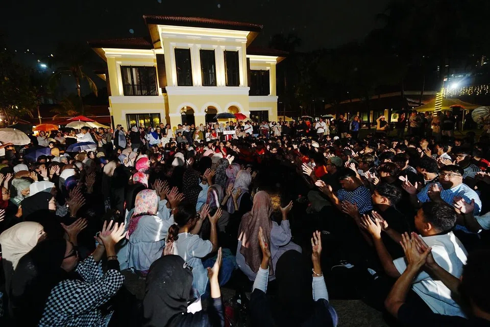 Suasana penutup Festival Belia DKSG (Dikir Singapura) 2026 diserikan dengan sesi ‘DKSG Jamming’ apabila peserta, penggiat seni dan pengunjung bersama-sama menyanyikan lagu ‘Eh Wau Bulan’ di bawah hujan di Taman Warisan Melayu pada 11 Julai.
