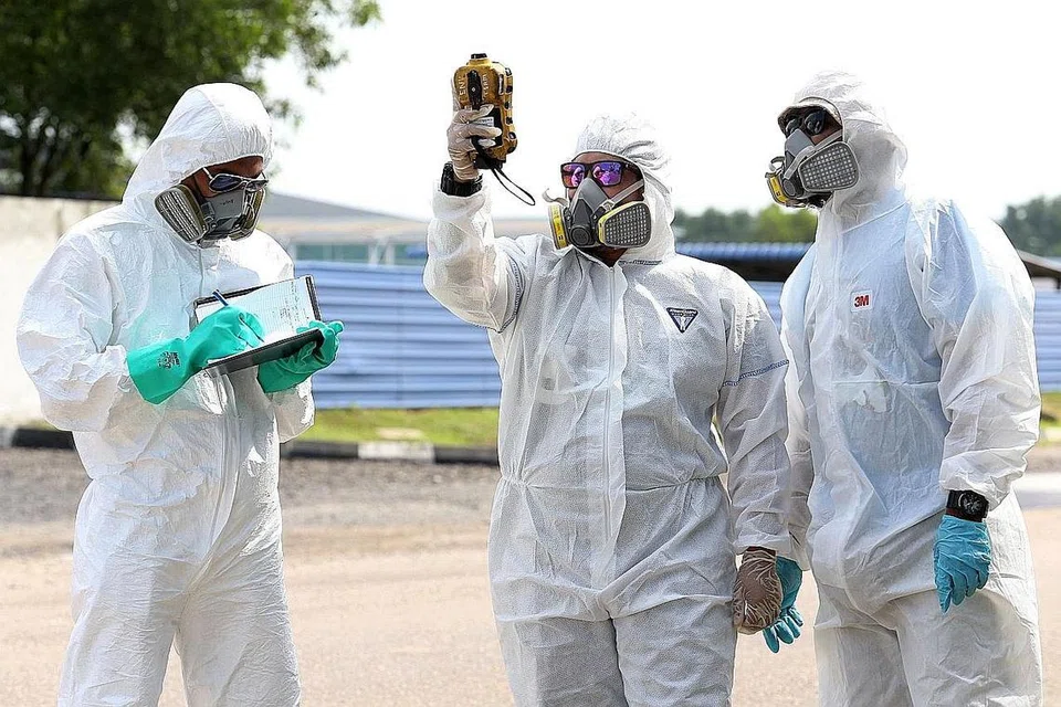 PENCEMARAN UDARA DI PASIR GUDANG: Anggota pasukan kecemasan memakai pakaian pelindung diri melakukan pemeriksaan mutu udara selepas asap toksik dilaporkan dikesan di kawasan berkenaan menyebabkan ratusan sekolah ditutup dan ramai jatuh sakit, yang dipercayai datang dari sebuah kilang kimia di kawasan berkenaan, menurut kenyataan pihak berkuasa pada 25 Jun lalu. - Foto AFP