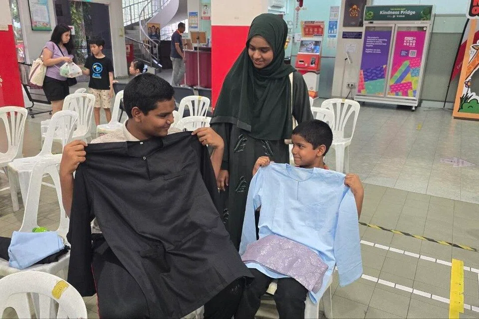 (Dari kiri) Abdurrahman Afeef Mohamed Yousouf, Amnah Marliyyah Mohamed Yousouf dan Muhammad Ibrahim Mohamed Yousouf dengan pakaian baru Hari Raya yang mereka memilih di Kompleks Joo Chiat.