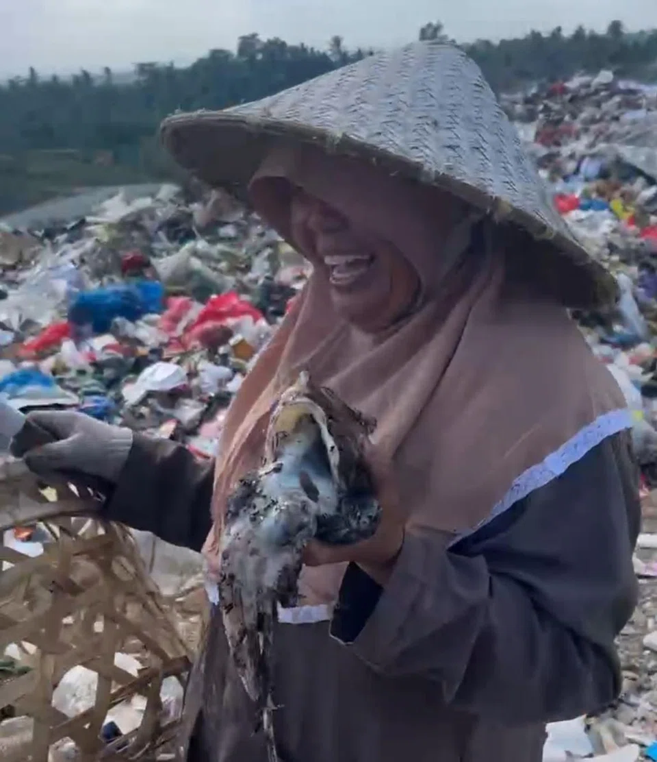 Seorang wanita separuh umur terlihat begitu bahagia membawa sotong yang dikutip dalam timbunan sampah sarap di Bukit Sampah, Lombok.